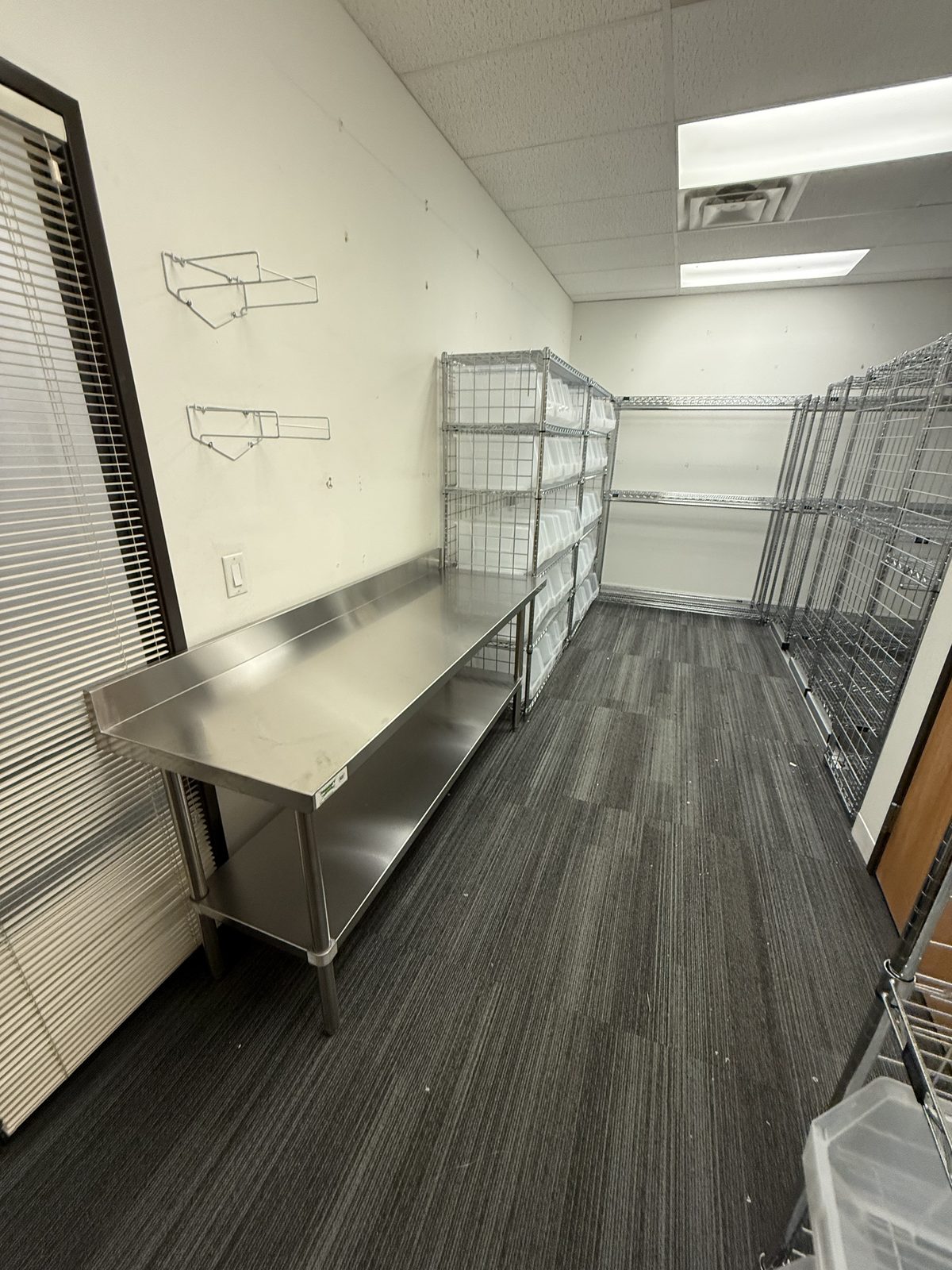Albuquerque uniform room full shelving overview with cubby racks and garment racks