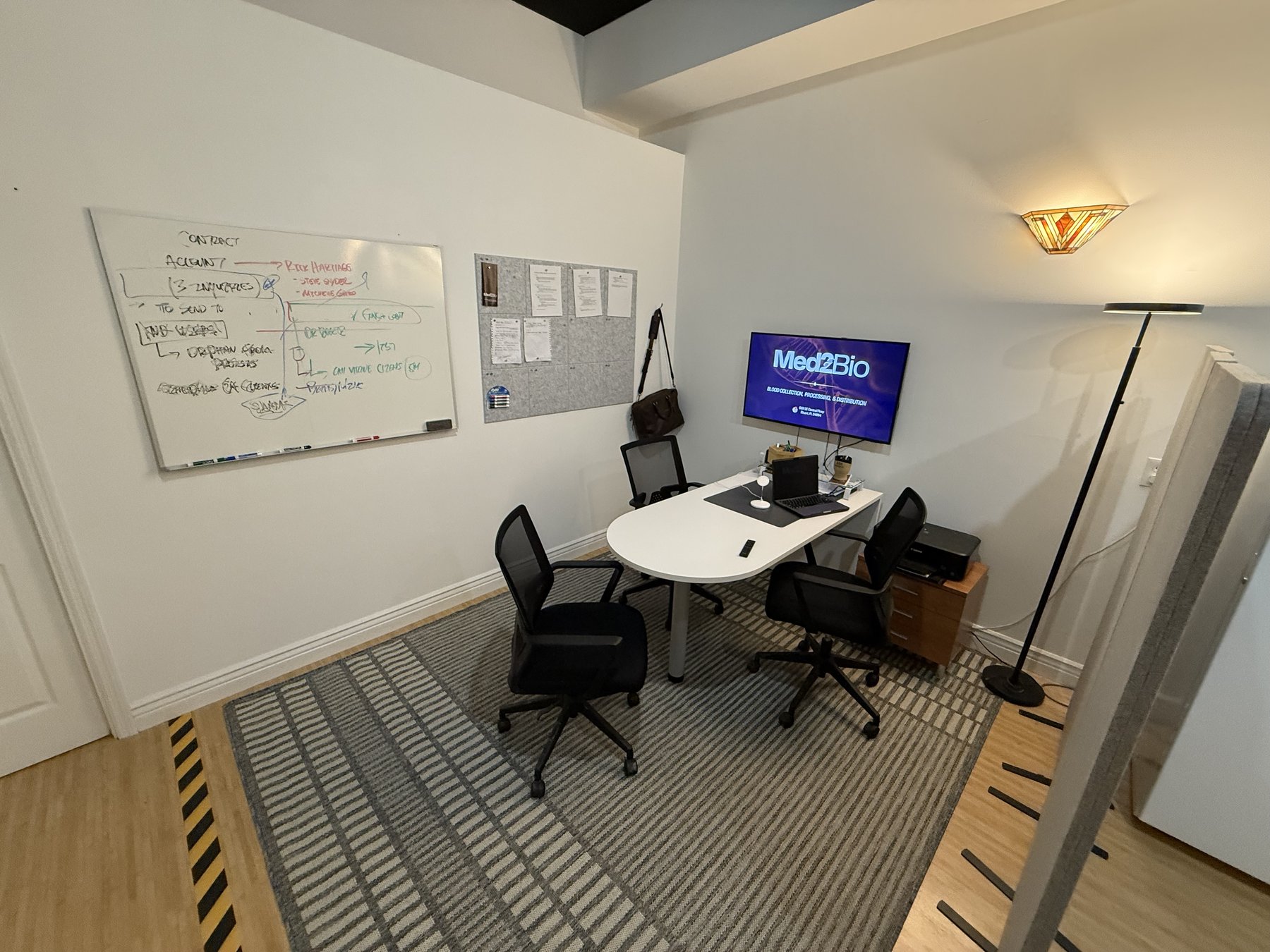 Med2Bio conference room with whiteboard and Med2Bio display