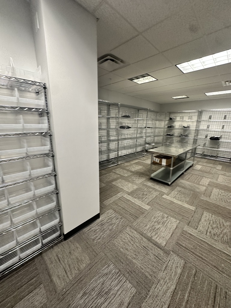 Storage room entrance with cubbie racks and island tables